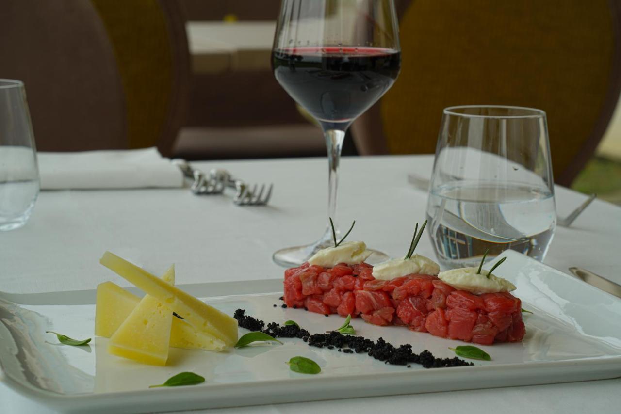 Pisa Tower Plaza Hotel ภายนอก รูปภาพ A glass of red wine with a plate of tartar